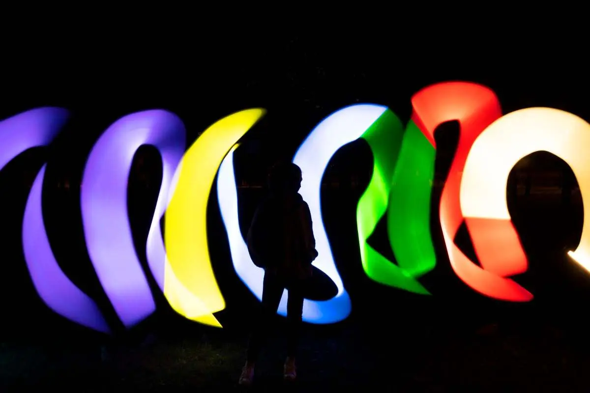 Projeção e iluminação cênica sobre as árvores do terreno